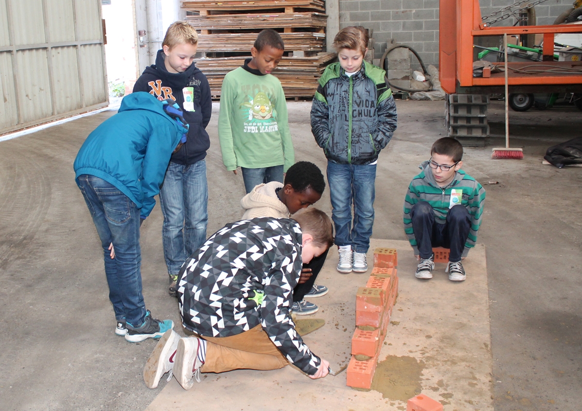 Les enfants construisent un mur chez le maçon
